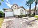Charming two-story home with tile roof, lush landscaping, and a paved driveway at 802 Brunello Dr, Davenport, FL 33897