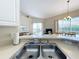 Bright kitchen featuring stainless steel sink, ample countertop space, and a seamless transition to the living area at 802 Brunello Dr, Davenport, FL 33897
