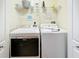 Convenient laundry room equipped with modern Maytag washer and dryer units and ample shelving at 802 Brunello Dr, Davenport, FL 33897