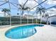 Inviting pool surrounded by a screened enclosure and lush landscaping for ultimate privacy at 802 Brunello Dr, Davenport, FL 33897