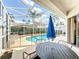 Screened lanai with a pool view features an outdoor dining area, chaise lounge, and a partial view of the yard at 802 Brunello Dr, Davenport, FL 33897