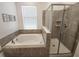 Bathroom featuring a large soaking tub and walk-in shower with gray tile surround at 8885 Cabot Cliffs Dr # 103, Davenport, FL 33896