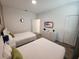 This bright bedroom features two beds, a wall-mounted TV, and simple white furnishings for a relaxing stay at 8885 Cabot Cliffs Dr # 103, Davenport, FL 33896