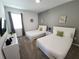 Cozy bedroom featuring two beds, a gray accent wall, and modern decor for a comfortable and stylish retreat at 8885 Cabot Cliffs Dr # 103, Davenport, FL 33896