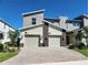 Modern townhome boasts a two-car garage, stone accents, and a neutral color scheme, exuding curb appeal at 8885 Cabot Cliffs Dr # 103, Davenport, FL 33896
