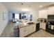 Open kitchen overlooks the living and dining areas, featuring white cabinetry and stainless steel appliances at 8885 Cabot Cliffs Dr # 103, Davenport, FL 33896