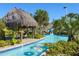 Relaxing lazy river at a community pool with colorful inflatable tubes and lush landscaping near a tiki hut at 8885 Cabot Cliffs Dr # 103, Davenport, FL 33896