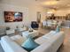Open-concept living room showcases stylish decor, seamlessly flowing into the dining area and kitchen at 8885 Cabot Cliffs Dr # 103, Davenport, FL 33896