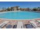 Large community pool with lounge chairs around the pool and community buildings in the background at 8885 Cabot Cliffs Dr # 103, Davenport, FL 33896