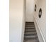This staircase is carpeted with white railings and wall decor, and is designed for a comfortable transition at 8885 Cabot Cliffs Dr # 103, Davenport, FL 33896