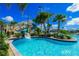 Community pool with a winding water slide for fun on a beautiful day with tropical landscaping at 8885 Cabot Cliffs Dr # 103, Davenport, FL 33896