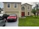 Two-story home featuring a two car garage and an orange front door at 920 Gillingham Ct, Kissimmee, FL 34758