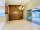 Dining room featuring tile flooring, wood-paneled accent wall, chandelier and sliding glass door with access to the lanai at 9404 Montello Dr, Orlando, FL 32817