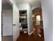 Spacious hallway featuring hardwood floors, an arched doorway, and a linen closet for ample storage at 11446 Jasper Kay Ter # 106, Windermere, FL 34786