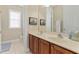 Bathroom with dual sinks, wooden cabinets, tile flooring, and natural lighting at 1160 Wilde Dr, Celebration, FL 34747