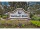 Elegant stone sign for Sawgrass Pointe community, surrounded by lush landscaping and mature trees at 12108 Sumter Dr, Orlando, FL 32824