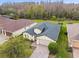 Aerial view of a home with a dark roof, brick driveway, and green lawn at 1398 Del Mar Dr, Kissimmee, FL 34759