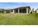 Exterior view of a home showcasing the screened lanai and a lush, green lawn at 1398 Del Mar Dr, Kissimmee, FL 34759