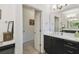 Bathroom vanity area with black cabinets, white countertop, a large mirror, and doorway leading to another room at 1398 Del Mar Dr, Kissimmee, FL 34759