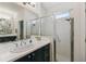 Well-lit bathroom featuring a shower with glass doors and a black vanity with a white countertop at 1398 Del Mar Dr, Kissimmee, FL 34759