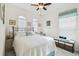 Cozy bedroom featuring a comfortable bed, fan, two windows with window treatments and charming decor at 1398 Del Mar Dr, Kissimmee, FL 34759