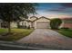 Charming single-Gathering home featuring brick driveway, attached two-car garage, and freshly manicured landscaping at 1398 Del Mar Dr, Kissimmee, FL 34759