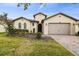 Single-Gathering home featuring brick driveway, two-car garage, arched windows and manicured front yard at 1398 Del Mar Dr, Kissimmee, FL 34759