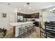Kitchen featuring dark wood cabinets, stainless steel appliances, a breakfast bar and an adjacent dining area at 1398 Del Mar Dr, Kissimmee, FL 34759