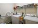 Functional laundry room equipped with a washer, dryer, storage shelves, and laundry supplies at 1398 Del Mar Dr, Kissimmee, FL 34759