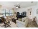 Bright living room featuring comfortable sofas, large window, ceiling fan, and wood rocking chair at 1398 Del Mar Dr, Kissimmee, FL 34759