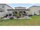 Backyard view of a covered patio featuring outdoor seating and a grill perfect for entertaining guests at 1669 Swan Swim Dr, Davenport, FL 33837