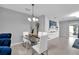 Bright dining area features a modern glass table, white chairs, a decorative wall, and tiled flooring at 1669 Swan Swim Dr, Davenport, FL 33837