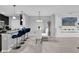 Bright dining area features a modern glass table, white chairs, blue bar stools, and tiled flooring at 1669 Swan Swim Dr, Davenport, FL 33837