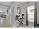 Stylish foyer with tile flooring, gray walls, a modern glass table, and large window with decorative mirror at 1669 Swan Swim Dr, Davenport, FL 33837