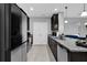Modern kitchen with granite countertops, dark wood cabinets, stainless steel appliances, and tiled flooring at 1669 Swan Swim Dr, Davenport, FL 33837