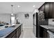 Modern kitchen with granite countertops, dark wood cabinets and stainless steel refrigerator at 1669 Swan Swim Dr, Davenport, FL 33837
