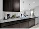 This kitchen has granite countertops, dark wood cabinets, and stainless steel appliances at 1669 Swan Swim Dr, Davenport, FL 33837