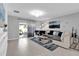 Bright living room with tile flooring, gray walls, modern lighting, and access to the outdoor patio at 1669 Swan Swim Dr, Davenport, FL 33837