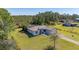 A home with screened-in pool on a large lot, surrounded by trees, is shown in this aerial view at 1741 Eldorado Ct, St Cloud, FL 34771