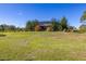 Expansive grassy backyard, with mature trees and screened pool in the distance, ideal for outdoor enjoyment and entertaining at 1741 Eldorado Ct, St Cloud, FL 34771
