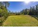 Picturesque backyard showcasing manicured green lawn with mature trees providing shade and enhancing privacy at 1741 Eldorado Ct, St Cloud, FL 34771