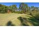 Spacious backyard featuring lush green grass and a backdrop of mature trees, offering privacy at 1741 Eldorado Ct, St Cloud, FL 34771