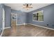 This bedroom is spacious with wood-look flooring, a ceiling fan, and natural light at 1741 Eldorado Ct, St Cloud, FL 34771