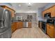 Spacious kitchen with stainless steel appliances, wooden cabinets, and open layout to the living room at 1741 Eldorado Ct, St Cloud, FL 34771