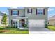 Two-story home featuring muted green paint, dark shutters, and a well-maintained front lawn at 1755 Buckeye Rd, Davenport, FL 33837