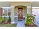 Charming front door with decorative wreath and pink hibiscus bush at 1755 Buckeye Rd, Davenport, FL 33837