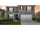 Two-story home featuring a two-car garage, manicured lawn, and charming front entrance at 1755 Buckeye Rd, Davenport, FL 33837