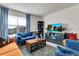 Comfortable living room with blue and orange sofas, a coffee table, and a large window at 1755 Buckeye Rd, Davenport, FL 33837