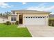 Charming two-story home featuring a well-manicured lawn and an attached two-car garage at 238 N Hampton Dr, Davenport, FL 33897