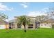 The backyard has a swimming pool surrounded by green grass, a palm tree, and a screened enclosure at 238 N Hampton Dr, Davenport, FL 33897